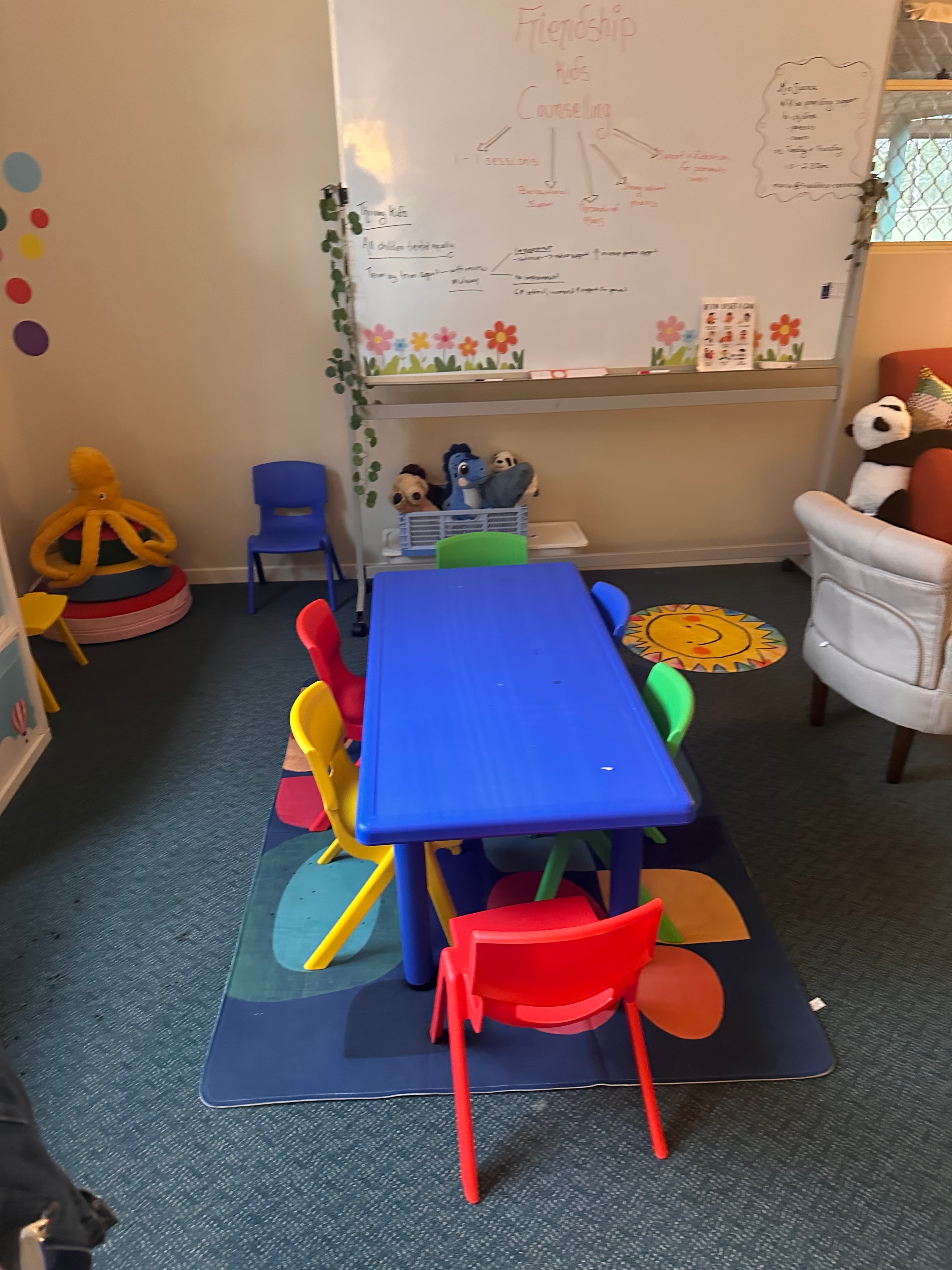 Colourful play table and whiteboard in the counselling centre